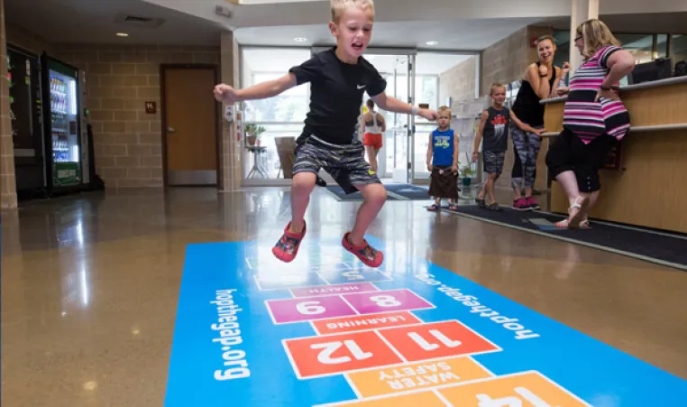 kid jumping on hop scotch board at Sampson Family Y YMCA Pittsburgh